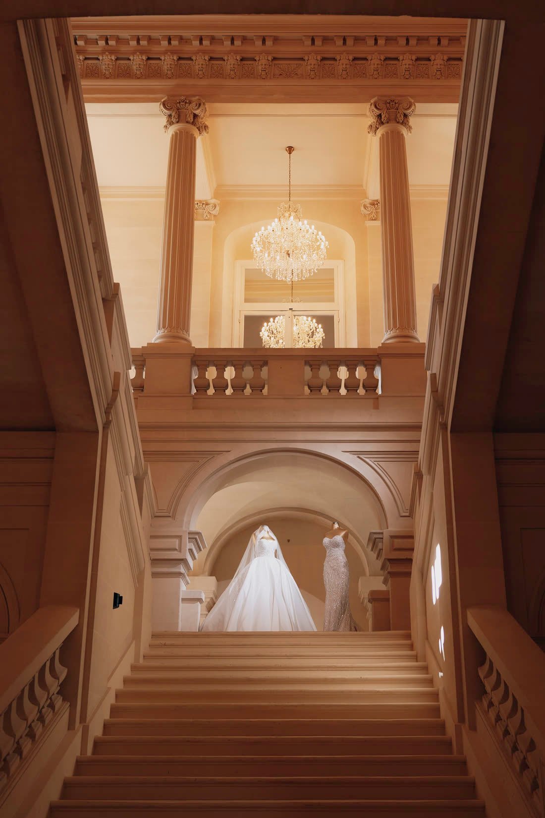 La robe de mariée au pied d'un grand escalier en pierre