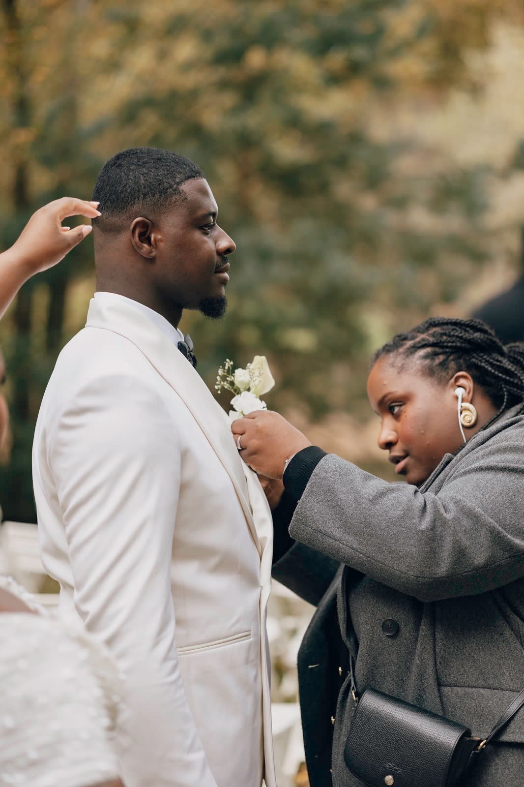 Une coordinatrice ajuste la boutonnière du marié