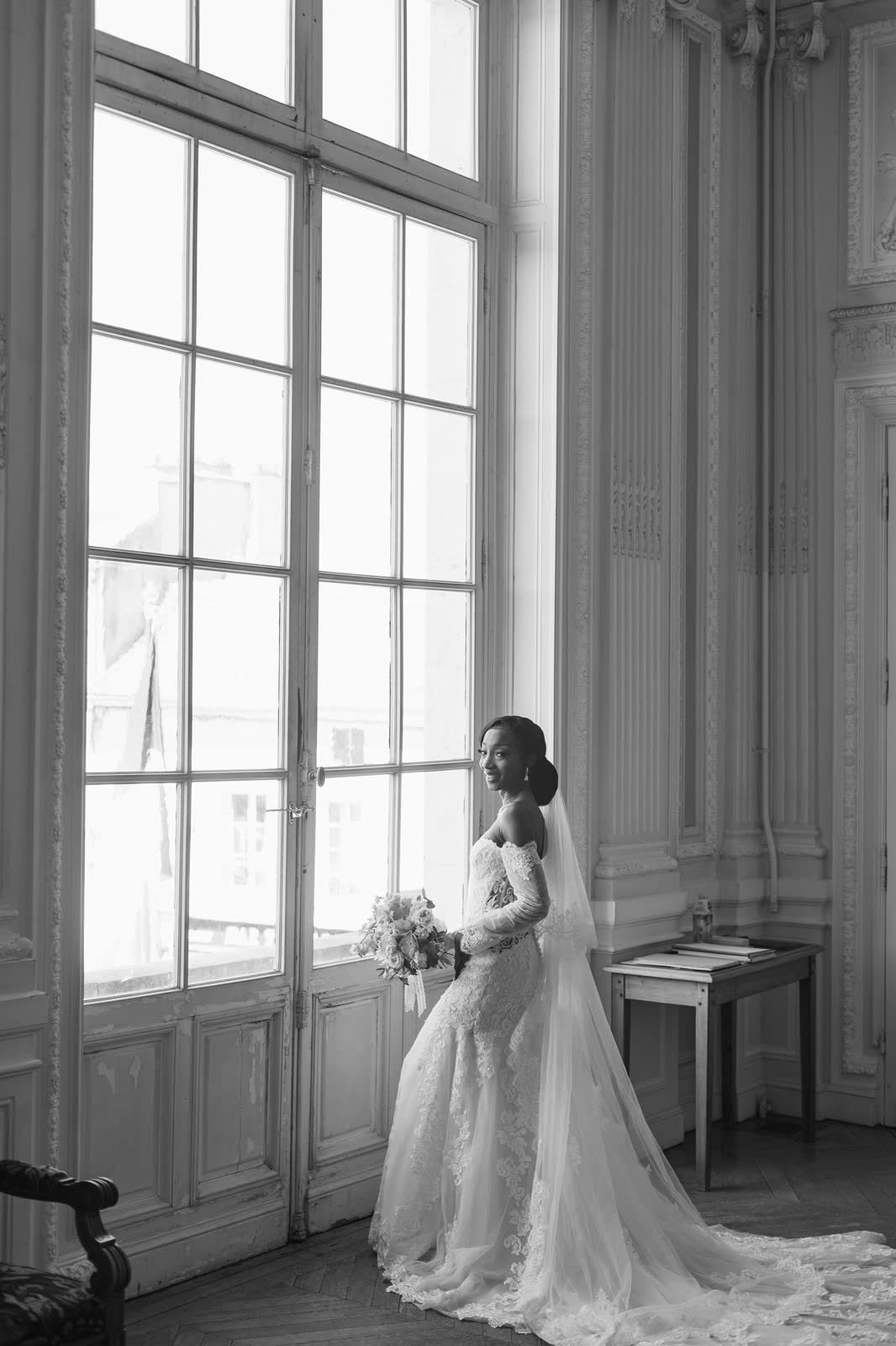 La mariée devant une grande fenêtre, en noir et blanc
